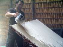 versement du lait d'hévéa sur les nappes de coton avant défumation pour la réasliation du Tissu de la forêt TAYGRA